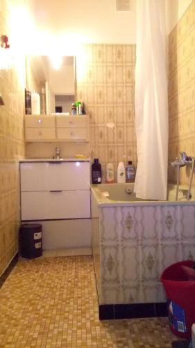 uma pequena casa de banho com um lavatório e um espelho em chambre lits jumeaux em Chevilly-Larue