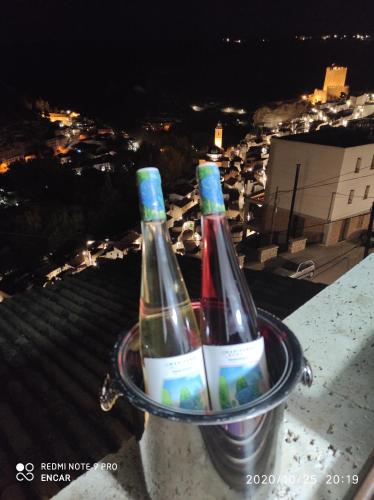 twee flessen wijn in een houder op een balkon bij El mirador 1 in Alcalá del Júcar