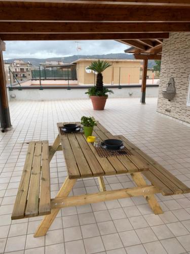 a wooden picnic table sitting on a patio at myrooftop a 10 min dalla Reggia di Caserta in Caserta