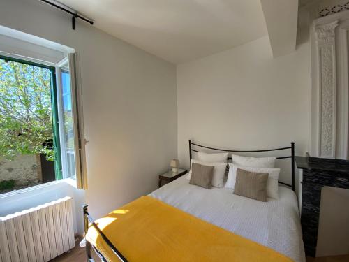 a bedroom with a bed and a large window at Gîte tout Confort au Coeur du Village Verniolle in Verniolle