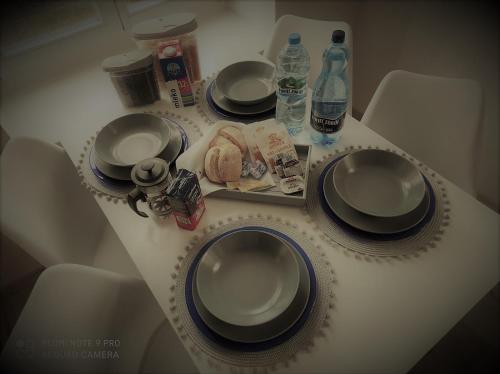 un tavolo con piatti e bottiglie d'acqua di Apartament Kuba a Mrągowo