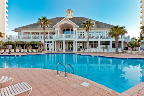 a large house with a swimming pool in front of it at The Beach Club Resort and Spa in Gulf Shores