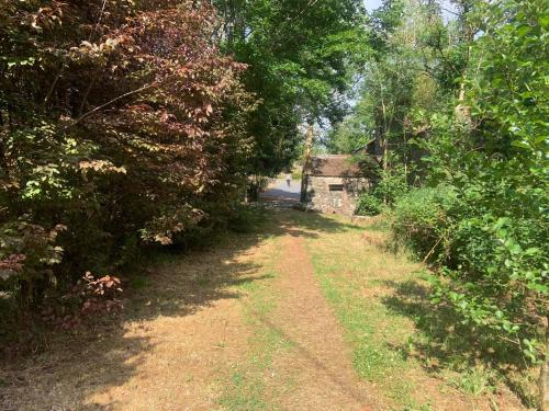 a dirt road with trees and a building in the distance at Lacken Millhouse and Gardens in Cavan