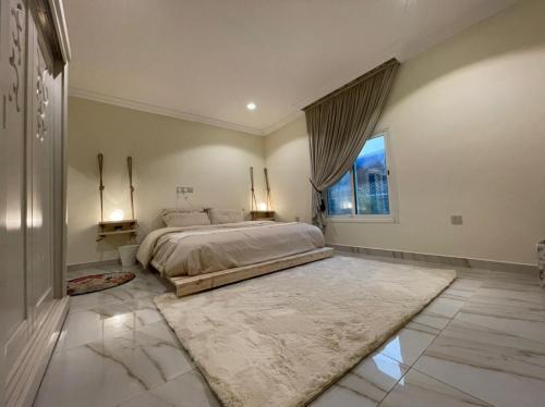 a bedroom with a large bed and a large window at شاليهات 4U vip in Dammam