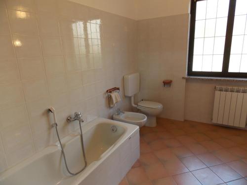a bathroom with a bath tub and a toilet at Antica Dimora del Portico in Borgiallo