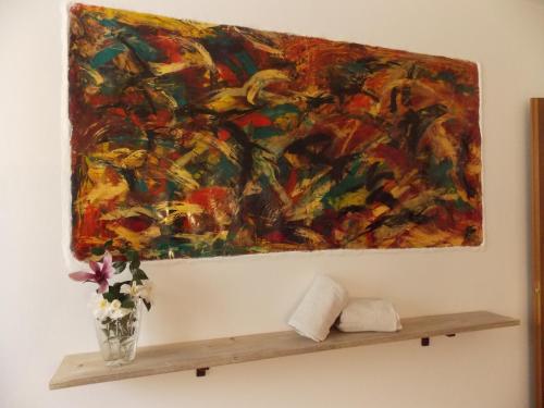 a painting hanging on a wall above a shelf at Antica Dimora del Portico in Borgiallo
