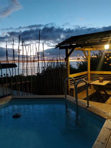 una piscina con vistas al océano al atardecer en Kreyol Lodges - Suite Kayou en Deshaies