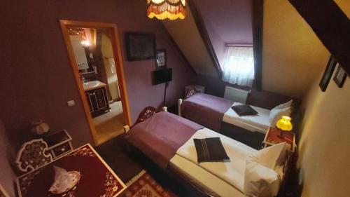 a small room with two beds and a mirror at Casa Saseasca in Sighişoara