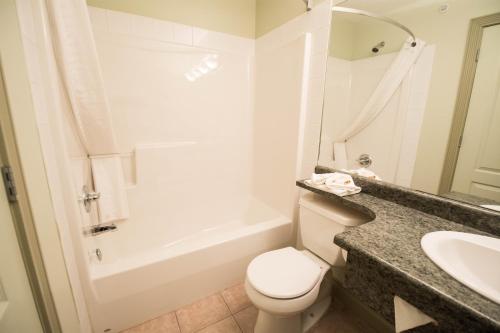 uma casa de banho com um WC, um lavatório e uma banheira em Nova Inn Acheson em Spruce Grove