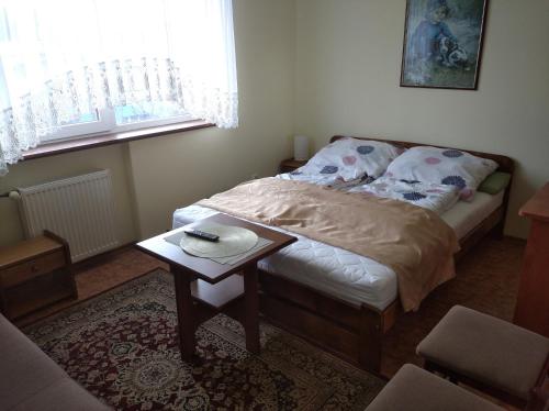 a small bedroom with a bed and a table at Akwarium in Międzywodzie