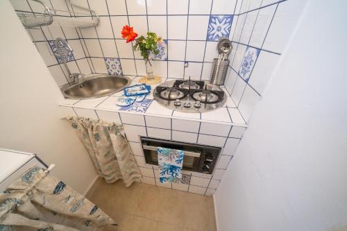 a small kitchen with a sink and a stove at VICOLO A MARE in Siracusa