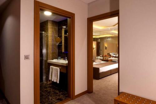 a bathroom with a shower and a sink and a mirror at MAJURA HOTEL BUSINESS in Karşıyaka