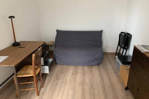 Cette petite chambre comprend un lit et un bureau. dans l'établissement Grand appartement lumineux au coeur de Saint Malo, à Saint-Malo