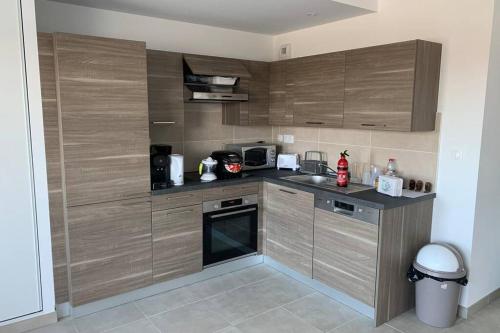 une cuisine avec des armoires en bois et un comptoir dans l'établissement Grand appartement lumineux au coeur de Saint Malo, à Saint-Malo