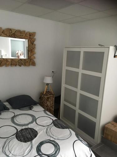 een slaapkamer met een bed en een spiegel bij L’appartement charmant in Dole