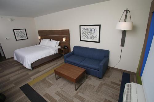 Pokój hotelowy z łóżkiem i niebieskim krzesłem w obiekcie Holiday Inn Express - McCook, an IHG Hotel w McCook