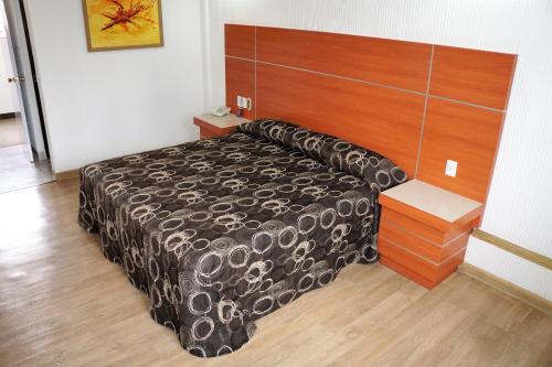 a bedroom with a bed and a wooden headboard at Hotel Principe in Mexico City