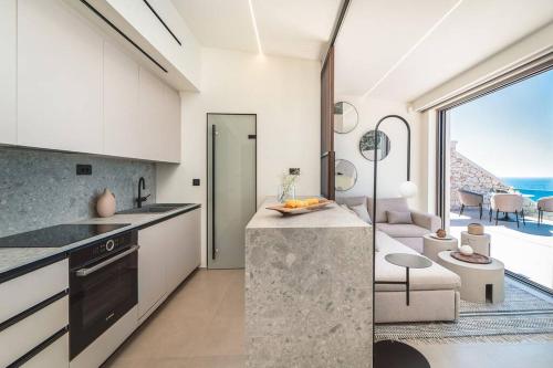 a kitchen with white cabinets and a view of the ocean at THE WAVE TWIN VILLA 2 KATHISMA BEACH Lefkada in Lefkada Town