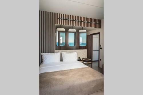 a bedroom with a white bed and two mirrors at THE WAVE TWIN VILLA 2 KATHISMA BEACH Lefkada in Lefkada Town