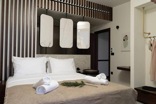 a bedroom with a bed with two towels on it at THE WAVE TWIN VILLA 2 KATHISMA BEACH Lefkada in Lefkada Town