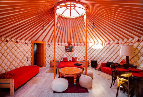 a yurt with a red couch and a table in it at Całoroczne jurty mongolskie - "Domy Słońca" in Kłodzko