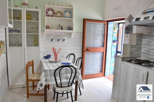 Un comedor con mesa y sillas y una cocina. en Casa vacanze da Anna, en Vietri