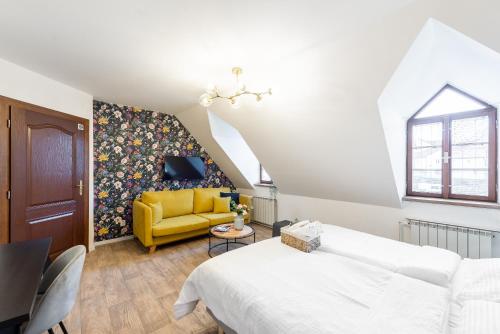 a bedroom with a bed and a yellow couch at Penzion Dubina in Litoměřice