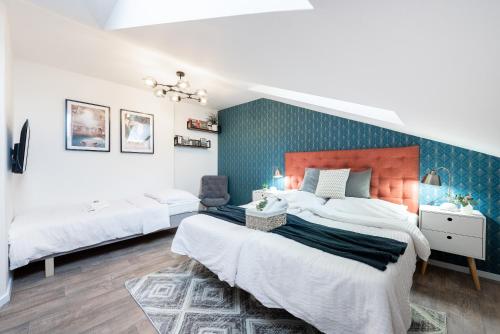 a bedroom with two beds and a blue accent wall at Penzion Dubina in Litoměřice