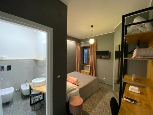 sypialnia z łóżkiem i umywalką oraz łazienka w obiekcie La Taverna Antica Rooms w mieście Pescara
