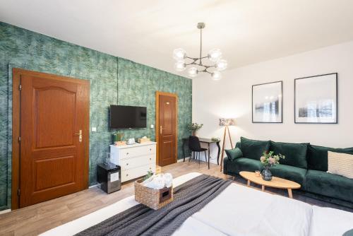 uma sala de estar com um sofá verde e uma televisão em Penzion Dubina em Litoměřice