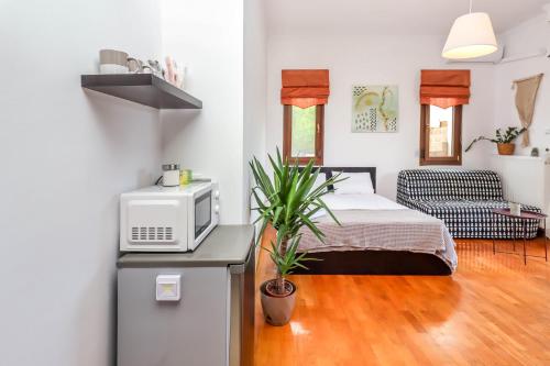 a small bedroom with a bed and a microwave at Suite Acropolis Serres With Parking Next to Center in Serres