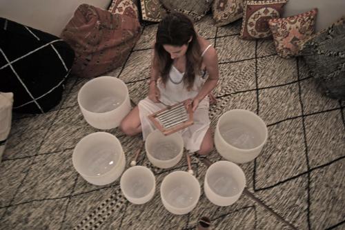 a woman sitting on the floor with white bowls at Hotel Casa Hormiga in Bacalar
