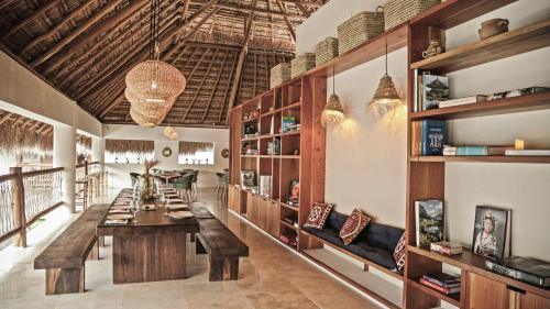 a dining room with a long table and benches at Hotel Casa Hormiga in Bacalar