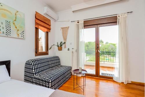 ein Schlafzimmer mit einem Bett, einem Stuhl und einem Fenster in der Unterkunft Suite Acropolis Serres Next To Center in Serres
