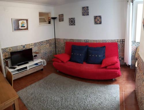 リスボンにあるLisbon City Centre Apartmentのリビングルーム(赤いソファ、テレビ付)
