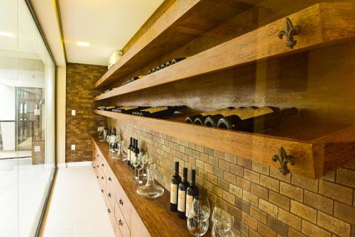 a wine cellar with bottles and glasses on a wall at Porto das Dunas Boutique Praia Hotel in Aquiraz