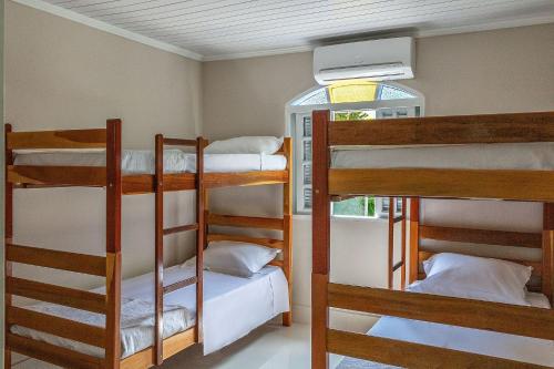 Una cama o camas en una habitación de Casa com churrasqueira e jardim perto da praia