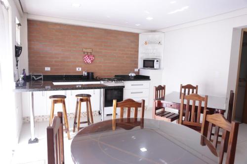 a kitchen with a table and some wooden chairs at Repouso Mantiqueira in Santo Antônio do Pinhal