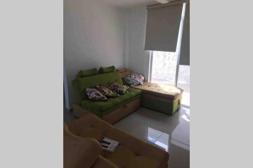 a living room with a green couch and a chair at Casa Quinta con piscina Girardot- Via el Peñón in Girardot