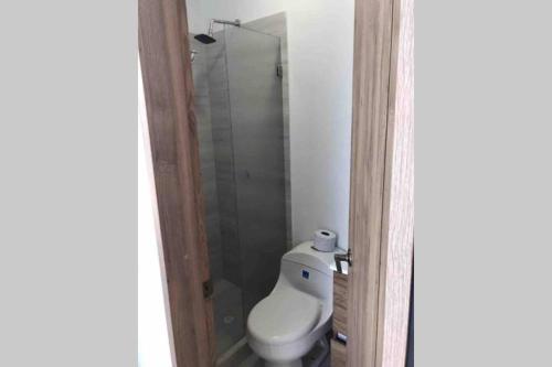 a bathroom with a toilet and a glass shower at Casa Quinta con piscina Girardot- Via el Peñón in Girardot