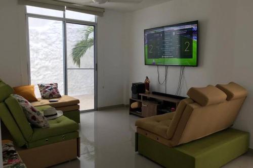 a living room with two chairs and a flat screen tv at Casa Quinta con piscina Girardot- Via el Peñón in Girardot