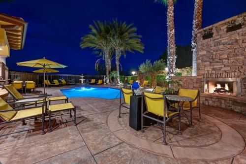 um pátio com lareira e uma piscina à noite em La Bellasera Hotel & Suites em Paso Robles