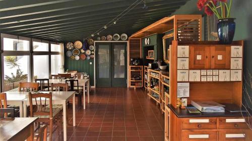 una sala da pranzo con tavoli e sedie e una stanza con tavoli e sedie di Quinta da Meia Eira a Horta