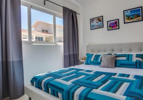 a bedroom with a bed and a large window at Apartamento Deluxe para Parejas en Punta Cana in Punta Cana