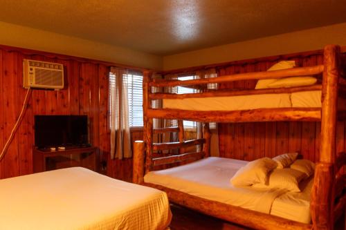 a bedroom with two bunk beds and a television at The Kern Lodge in Kernville