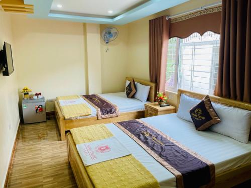 a hotel room with two beds and a window at Thanh Trung Hotel in Cat Ba