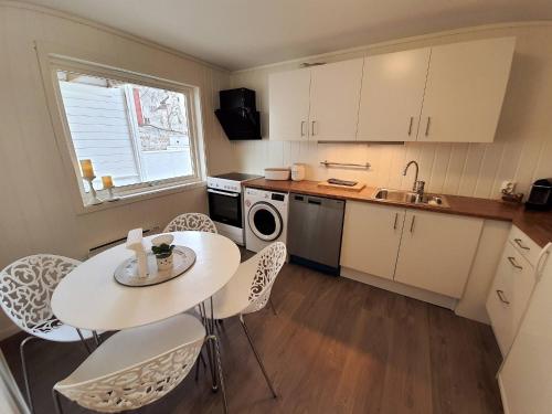 una pequeña cocina con mesa, sillas y fregadero en Bnb Central Apartment 5 Downtown Stavanger Stavanger, en Stavanger