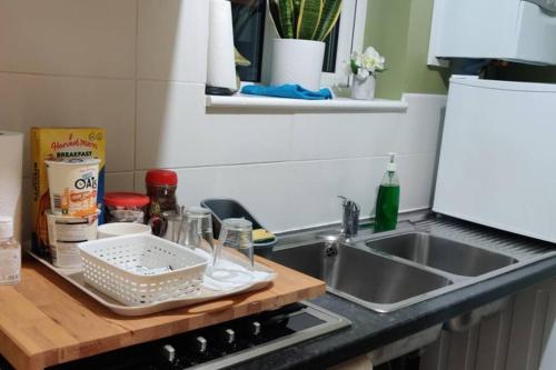 eine Küchentheke mit einem Sieb auf einem Tablett neben einer Spüle in der Unterkunft Private Comfortable Guest Suite - Nottingham in Nottingham