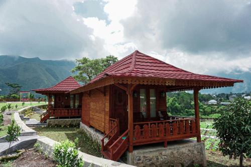 a small wooden building with a red roof at Rinjani Hill Hotel in Sembalun Lawang