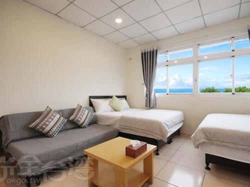 a living room with two beds and a couch at Shang Yuan in Green Island